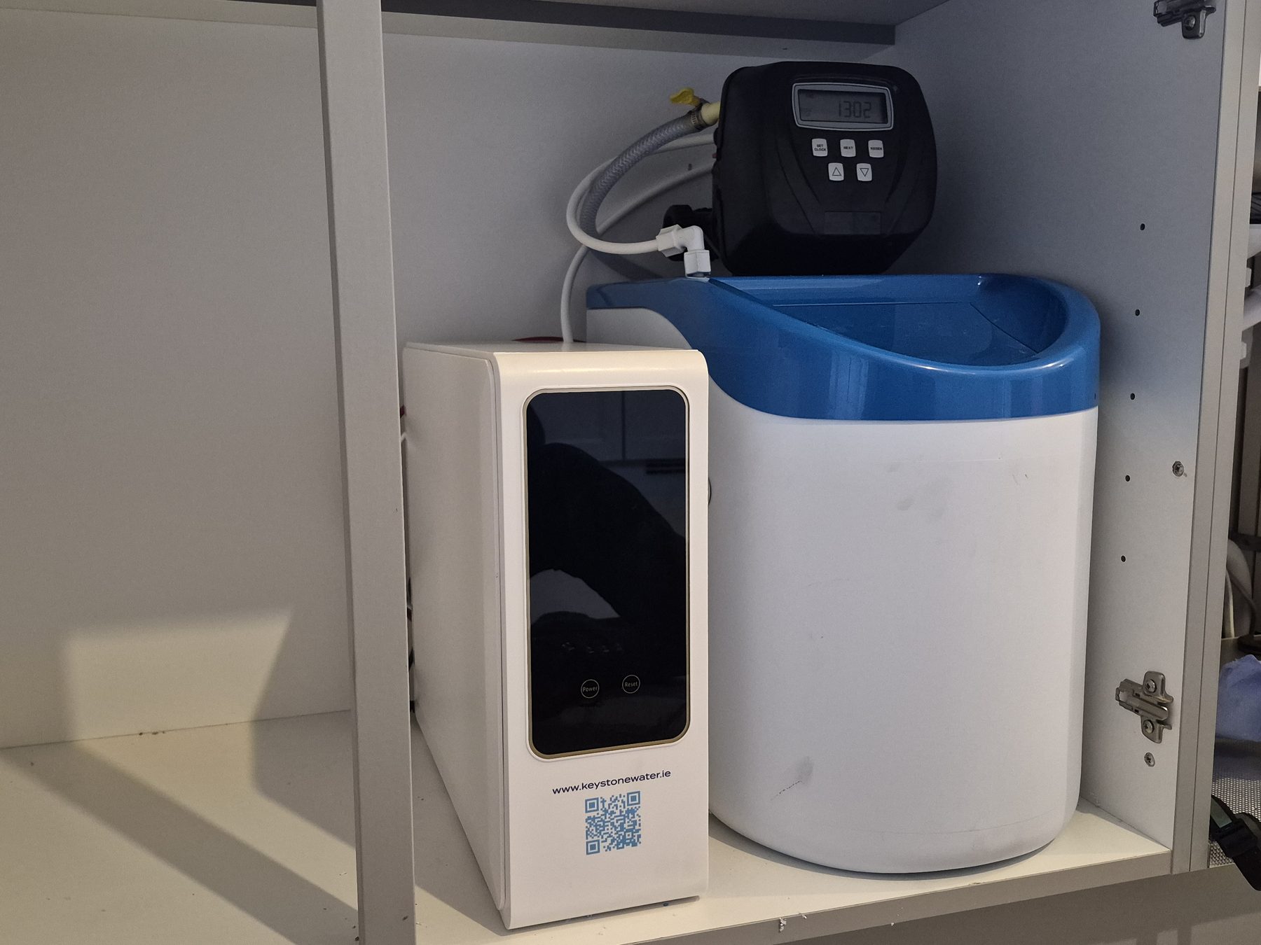 Compact under-sink water filter installed in a kitchen cabinet